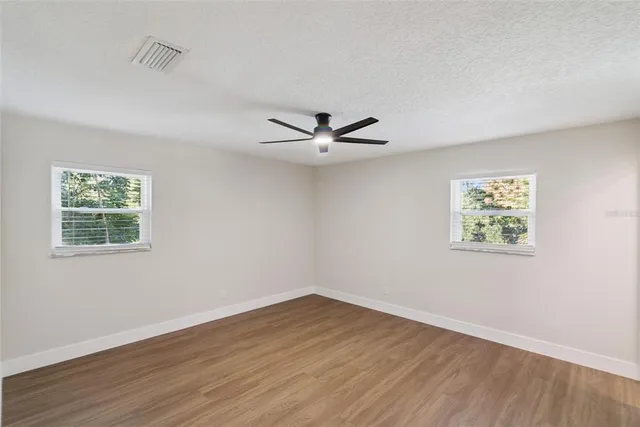 a view of a livingroom with wooden floor and a ceiling fan