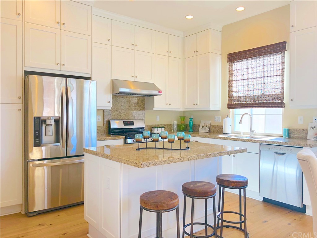 222 Firefly Irvine, CA 92618 - Photo 3 of 26 a kitchen with stainless steel appliances granite countertop a refrigerator a sink dishwasher a stove and white cabinets with wooden floor