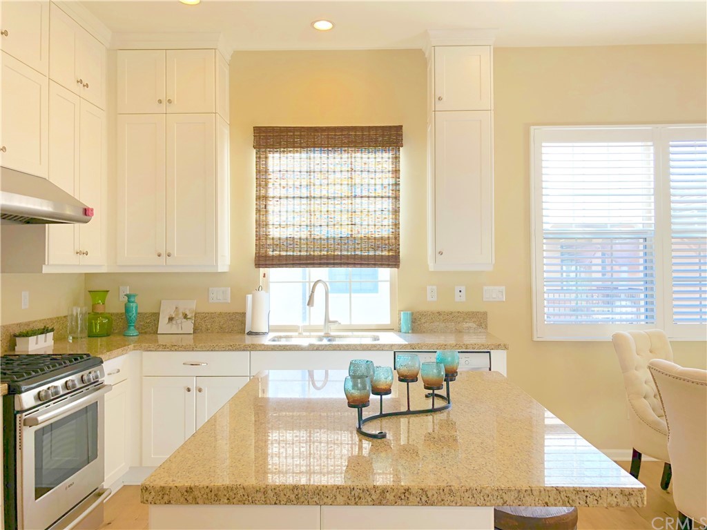 222 Firefly Irvine, CA 92618 - Photo 8 of 26 a kitchen with stainless steel appliances granite countertop a sink a stove a dining table and chairs