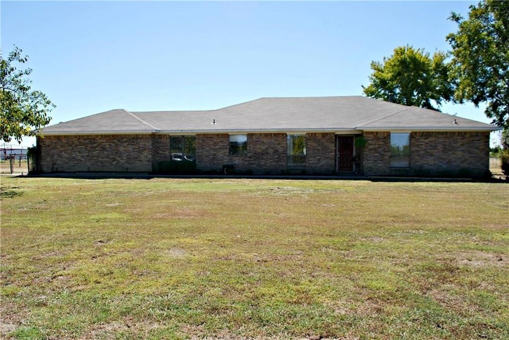 a view of a house with a yard and large tree