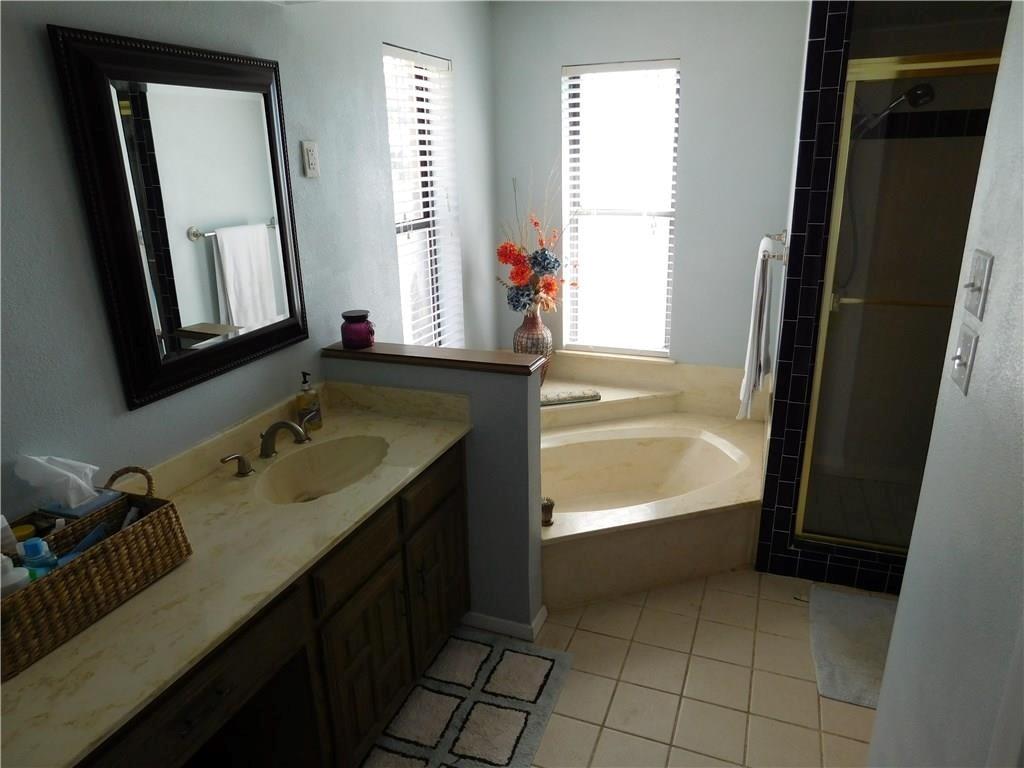 410 Barnes Bridge Road Sunnyvale, TX 75182 - Photo 15 of 20 a bathroom with a double vanity sink a mirror and a bathtub