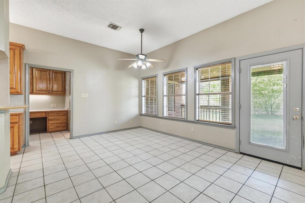 135 Private Road 2202 Decatur, TX 76234 - Photo 13 of 40 Unfurnished dining area featuring built in study area, ceiling fan, light tile patterned flooring, and lofted ceiling