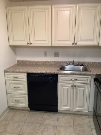 a kitchen with granite countertop white cabinets and sink