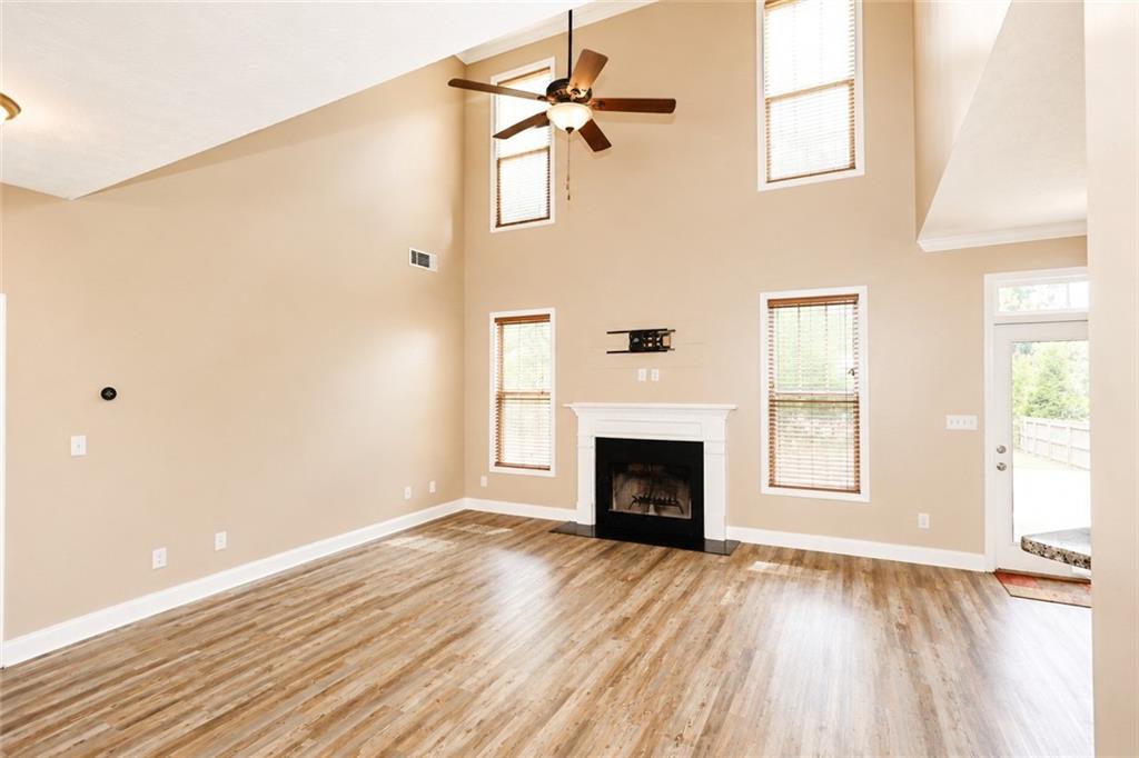 2078 Autumn Ridge Way Auburn, AL 36879 - Photo 10 of 24 Vaulted ceiling, wood-finish flooring, white mantel fireplace, ceiling fan, and multiple windows
