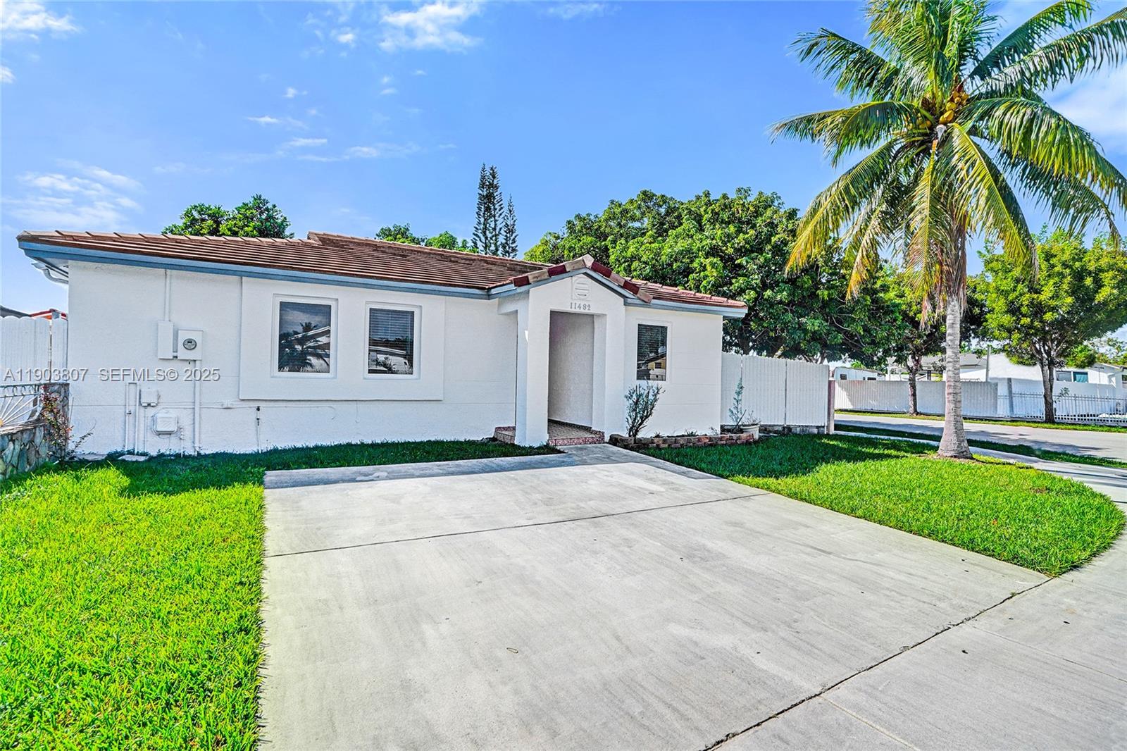 11482 Southwest 181st Street Miami, FL 33157 - Photo 2 of 35 a white house with a yard and plants