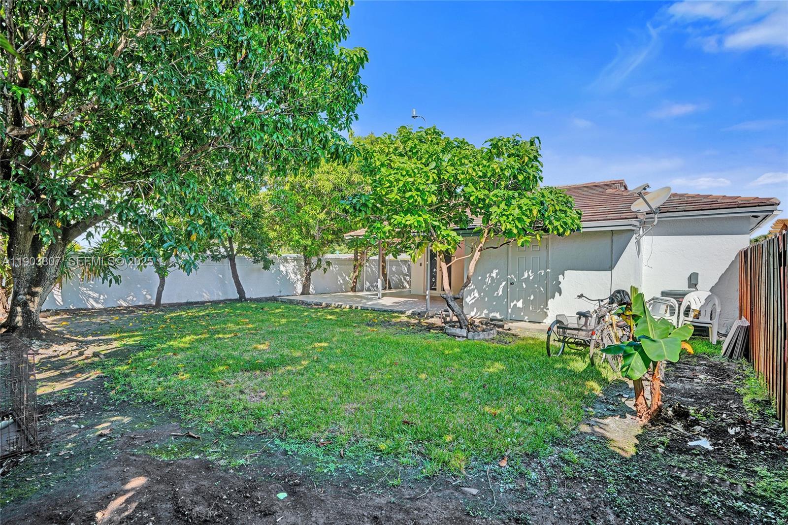 11482 Southwest 181st Street Miami, FL 33157 - Photo 29 of 35 a backyard of a house with table and chairs