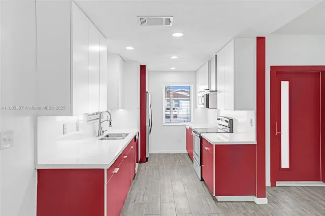 a kitchen with kitchen island granite countertop a sink a counter top space and stainless steel appliances
