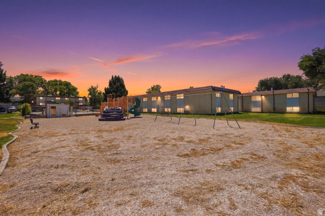 314 West Center Street, Unit F102 Bountiful, UT 84010 - Photo 28 of 29 Expansive common area featuring a playground with slides and swings, surrounded by established trees and green spaces