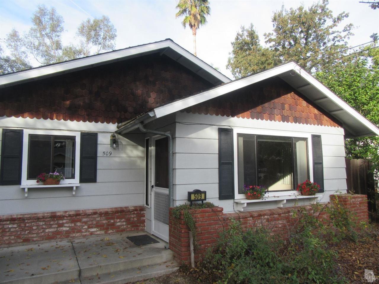 a view of a house with backyard porch and sitting area