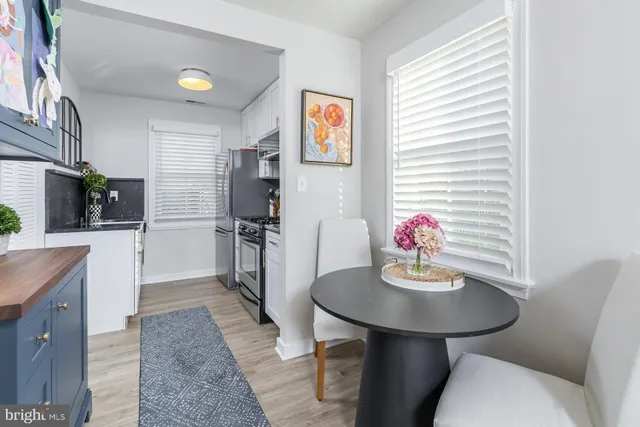 a kitchen with sink refrigerator dining table and chairs