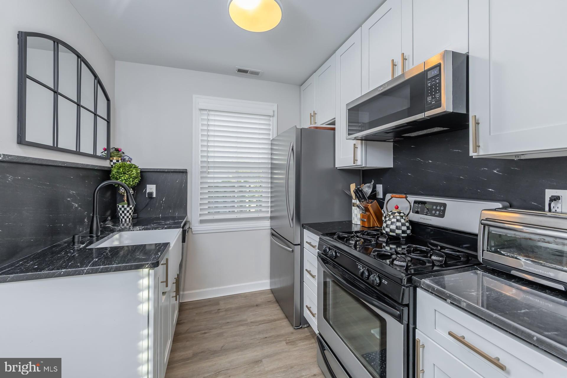 225 Spruce Street Haddonfield, NJ 08033 - Photo 15 of 28 a kitchen with stainless steel appliances granite countertop a sink stove and microwave
