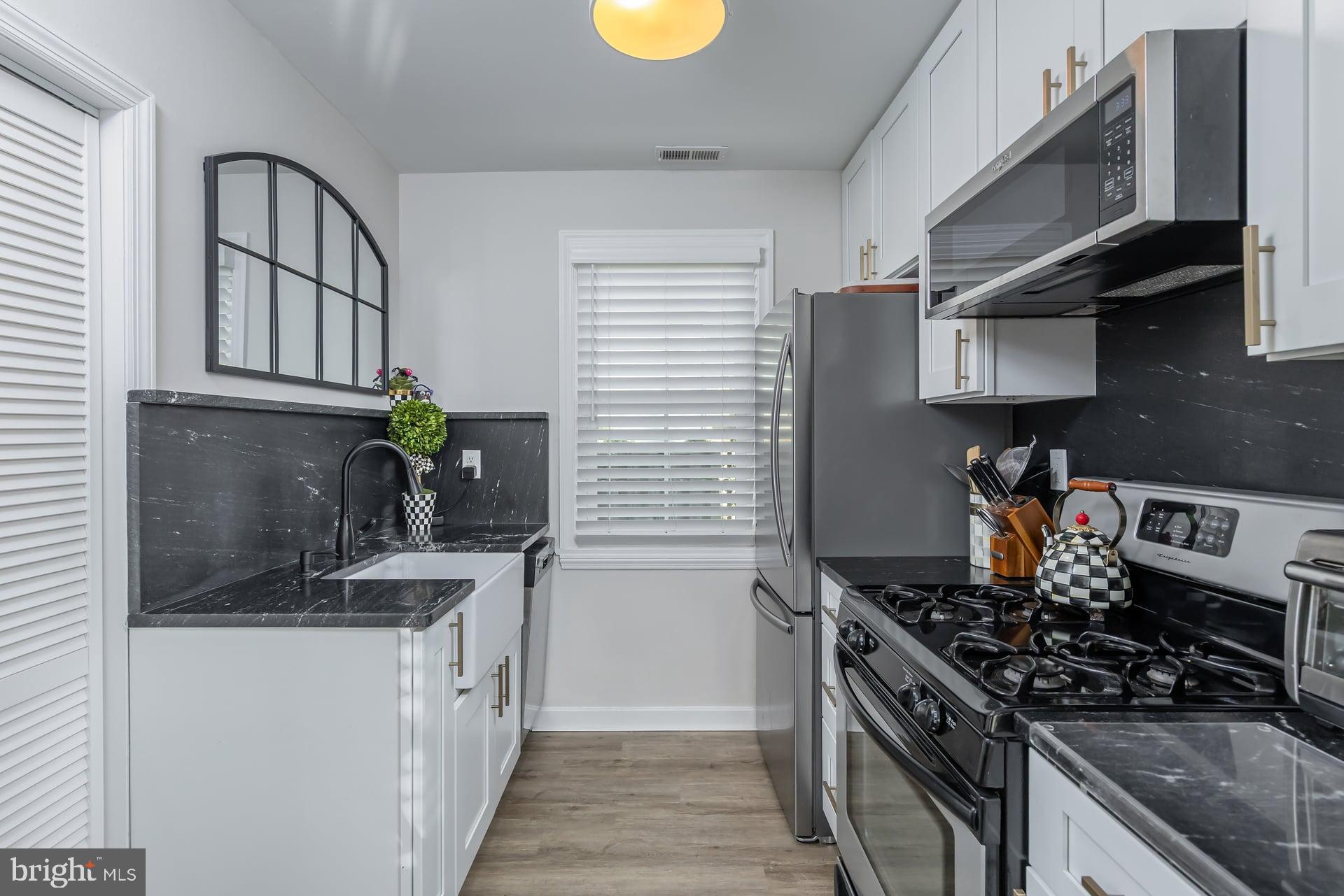 225 Spruce Street Haddonfield, NJ 08033 - Photo 16 of 28 a kitchen with stainless steel appliances granite countertop a stove a sink and a microwave