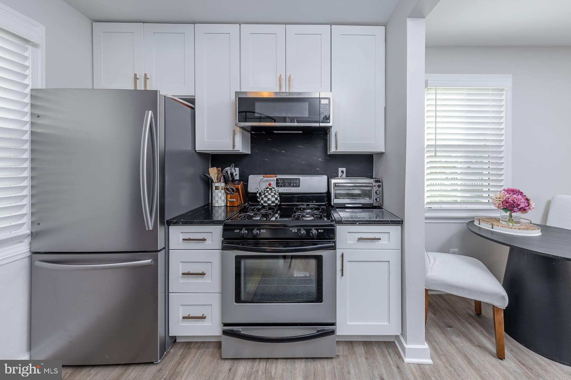 225 Spruce Street Haddonfield, NJ 08033 - Photo 18 of 28 a kitchen with stainless steel appliances wooden cabinets and a refrigerator