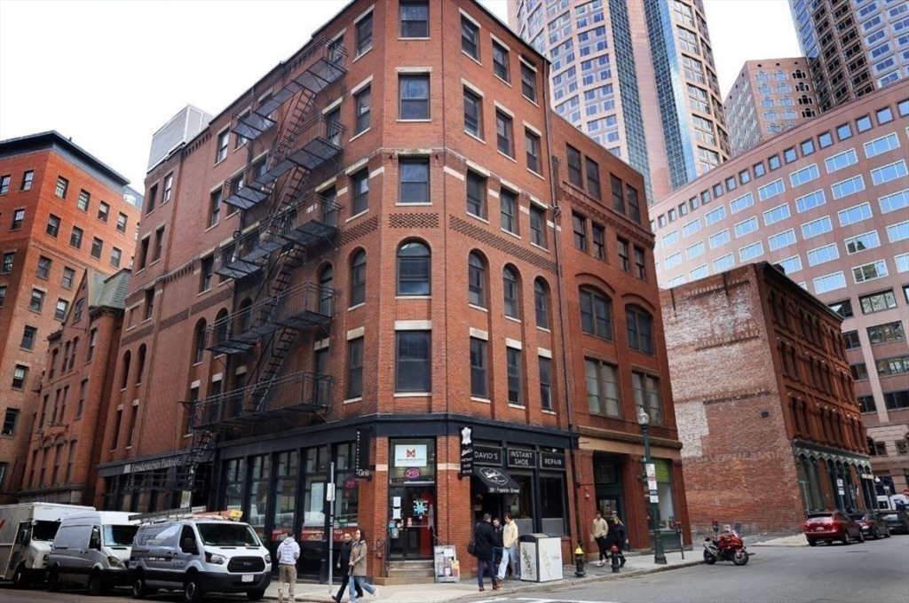 281 Franklin Street, Unit 503 Boston, MA 02110 - Photo 5 of 6 a front view of a building with lot of cars and trees