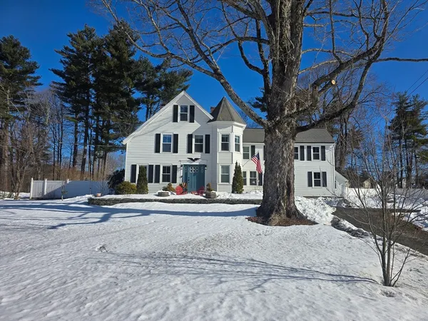 a front view of a house with a tree