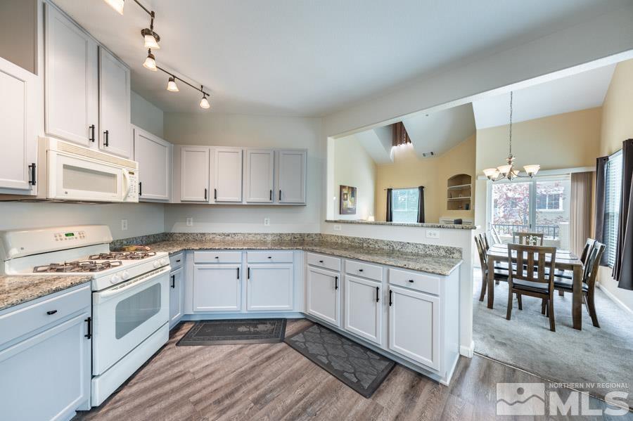 9050 Double R Boulevard Reno, NV 89521 - Photo 23 of 40 a kitchen with granite countertop white cabinets and white appliances