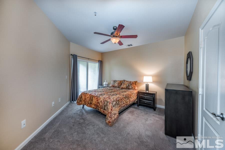 9050 Double R Boulevard Reno, NV 89521 - Photo 27 of 40 a bedroom with a bed and a chandelier