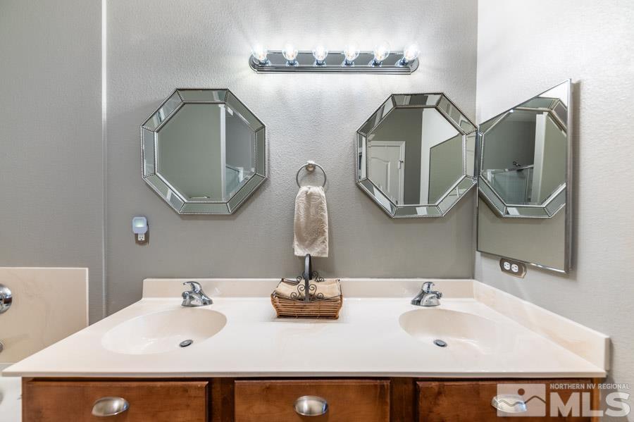 9050 Double R Boulevard Reno, NV 89521 - Photo 30 of 40 a bathroom with a double vanity sink and a mirror