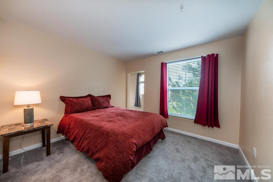 9050 Double R Boulevard Reno, NV 89521 - Photo 31 of 40 a bedroom with a bed and a lamp