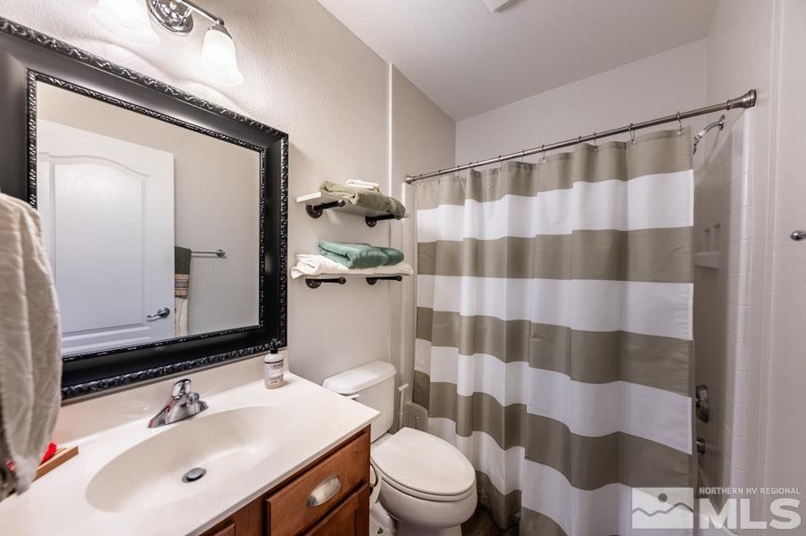 9050 Double R Boulevard Reno, NV 89521 - Photo 32 of 40 a bathroom with a sink a toilet a shower and a mirror