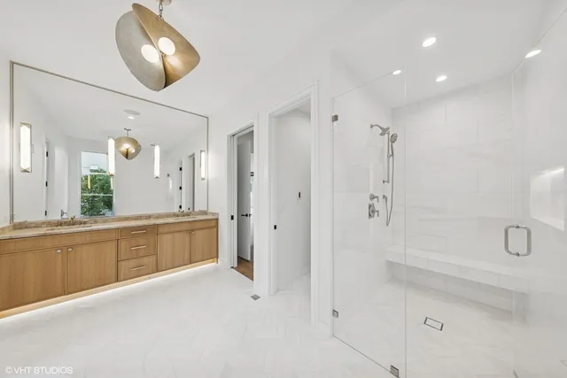 a spacious bathroom with a tub shower and mirror