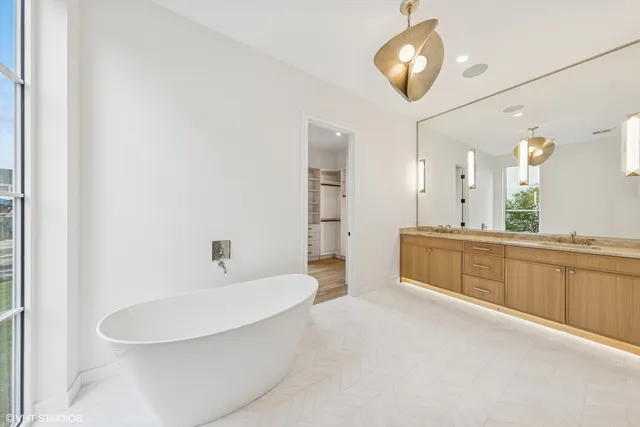 a bathroom with a sink a large mirror and a bathtub