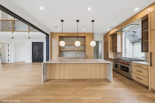 a large kitchen with stainless steel appliances granite countertop a stove a sink and a refrigerator