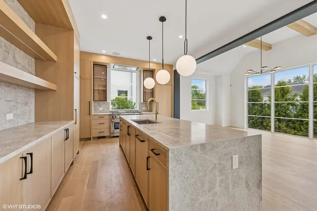 a large kitchen with kitchen island a large island in it