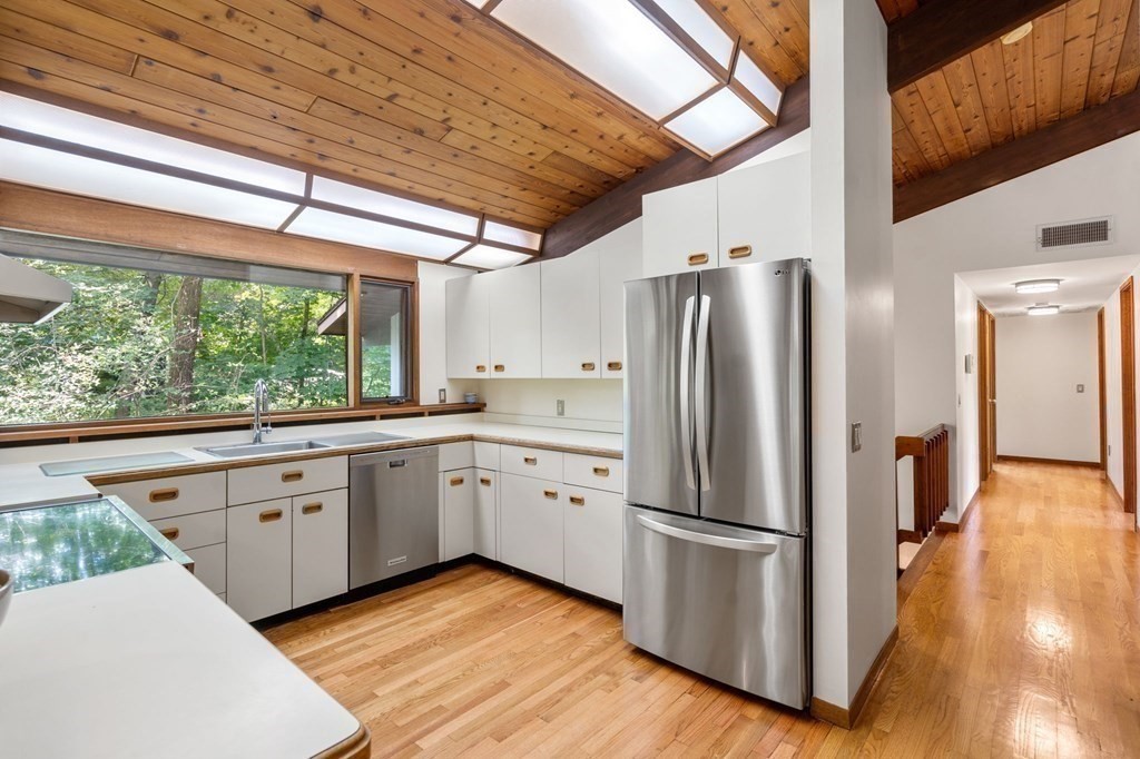 20 Meadowbrook Road Westwood, MA 02090 - Photo 14 of 36 a kitchen with stainless steel appliances granite countertop a refrigerator a sink dishwasher a stove and white countertops with wooden floor