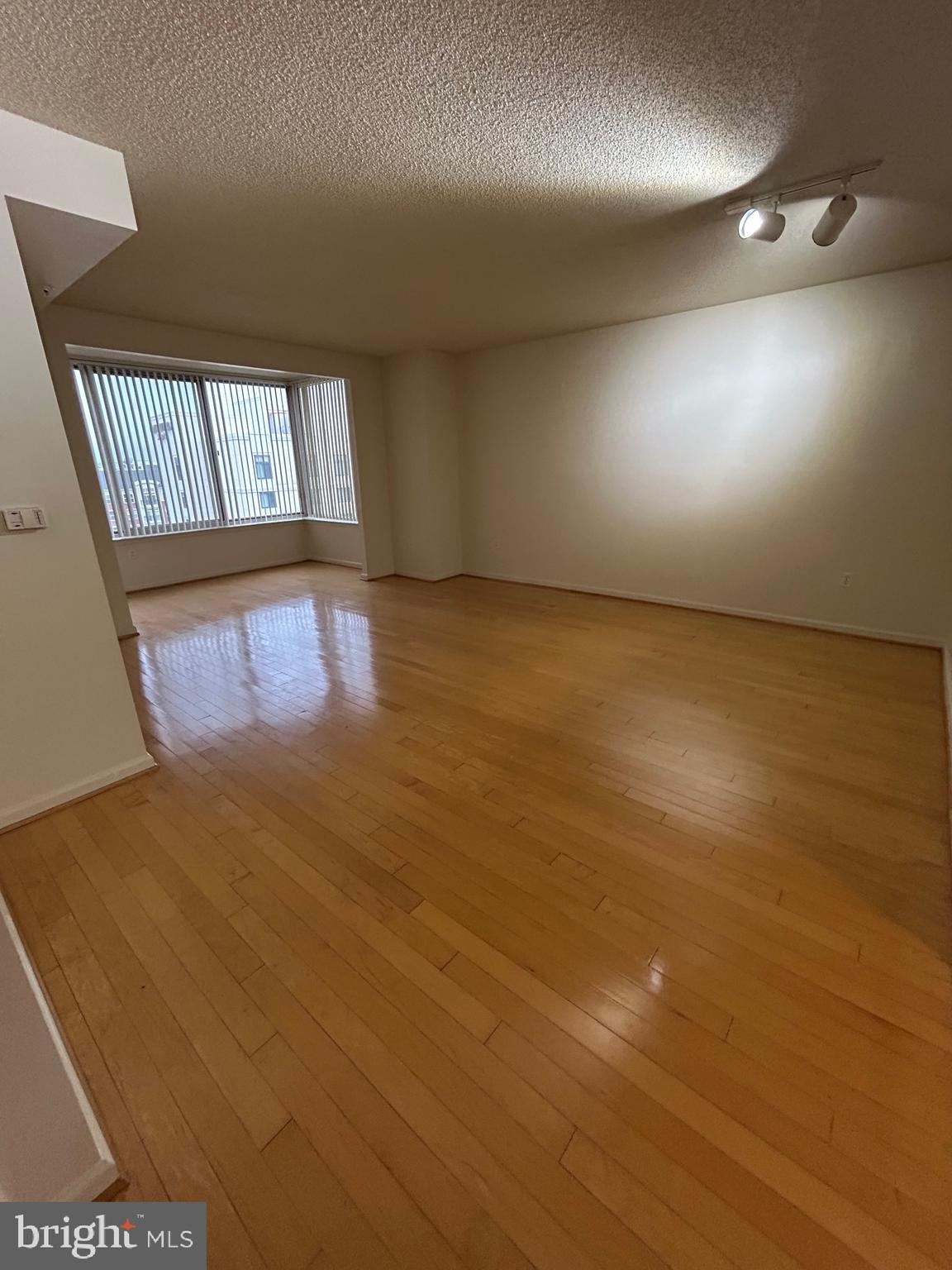 2726 Gallows Road, Unit 1104 Vienna, VA 22180 - Photo 14 of 37 an empty room with wooden floor and windows