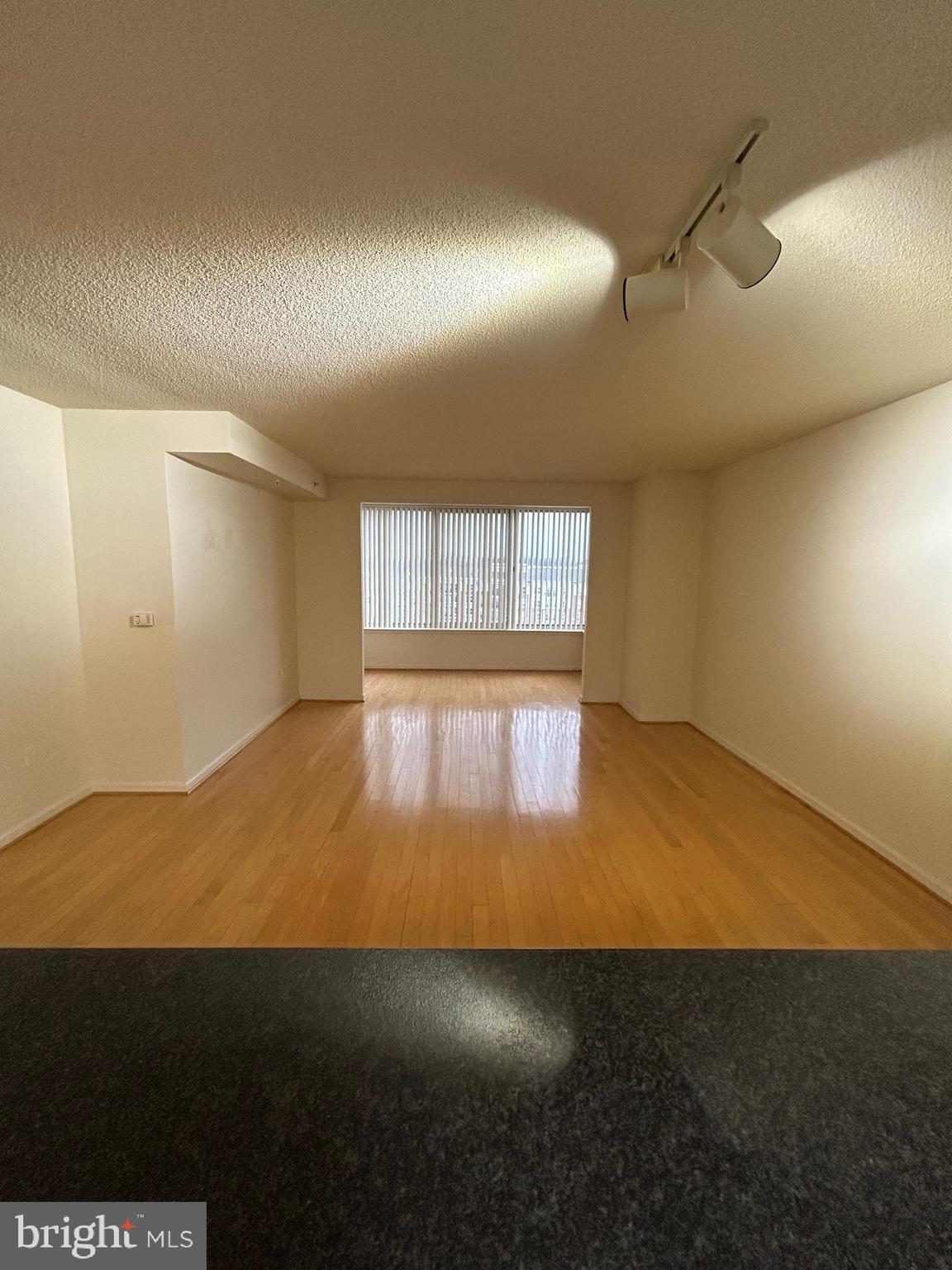2726 Gallows Road, Unit 1104 Vienna, VA 22180 - Photo 16 of 37 an empty room with wooden floor and windows