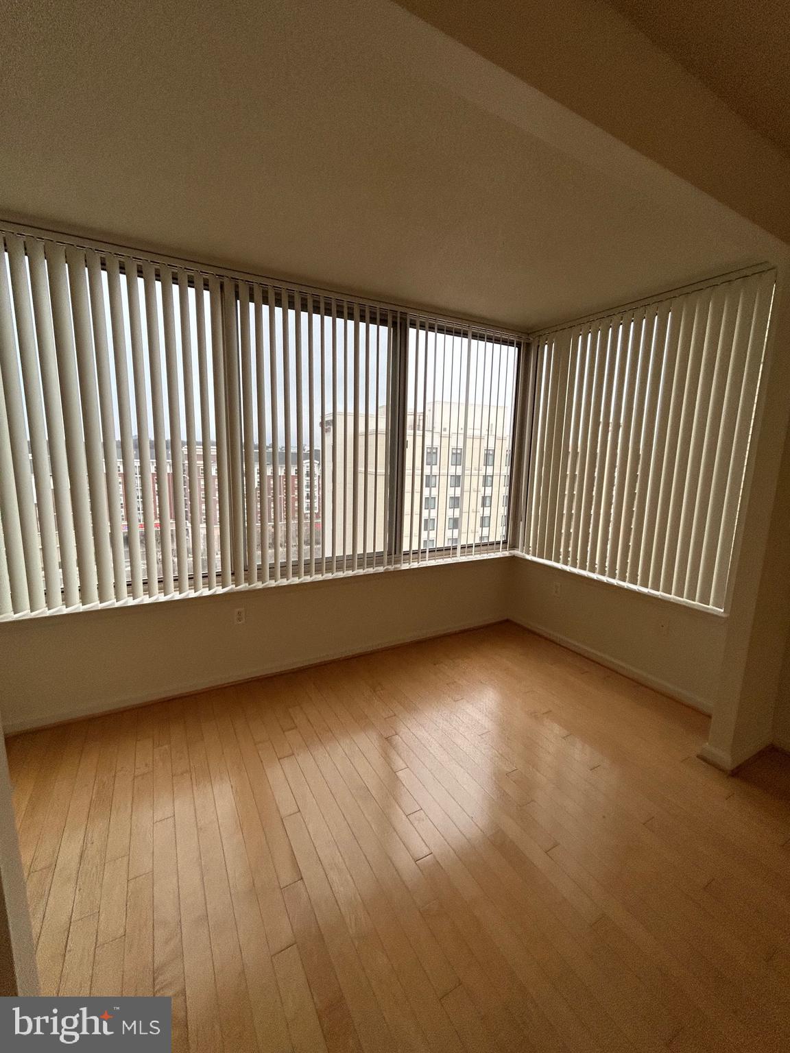 2726 Gallows Road, Unit 1104 Vienna, VA 22180 - Photo 17 of 37 an empty room with wooden floor and windows
