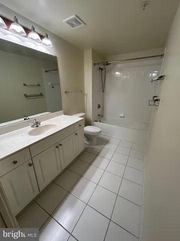 a spacious bathroom with a double vanity sink toilet and a mirror