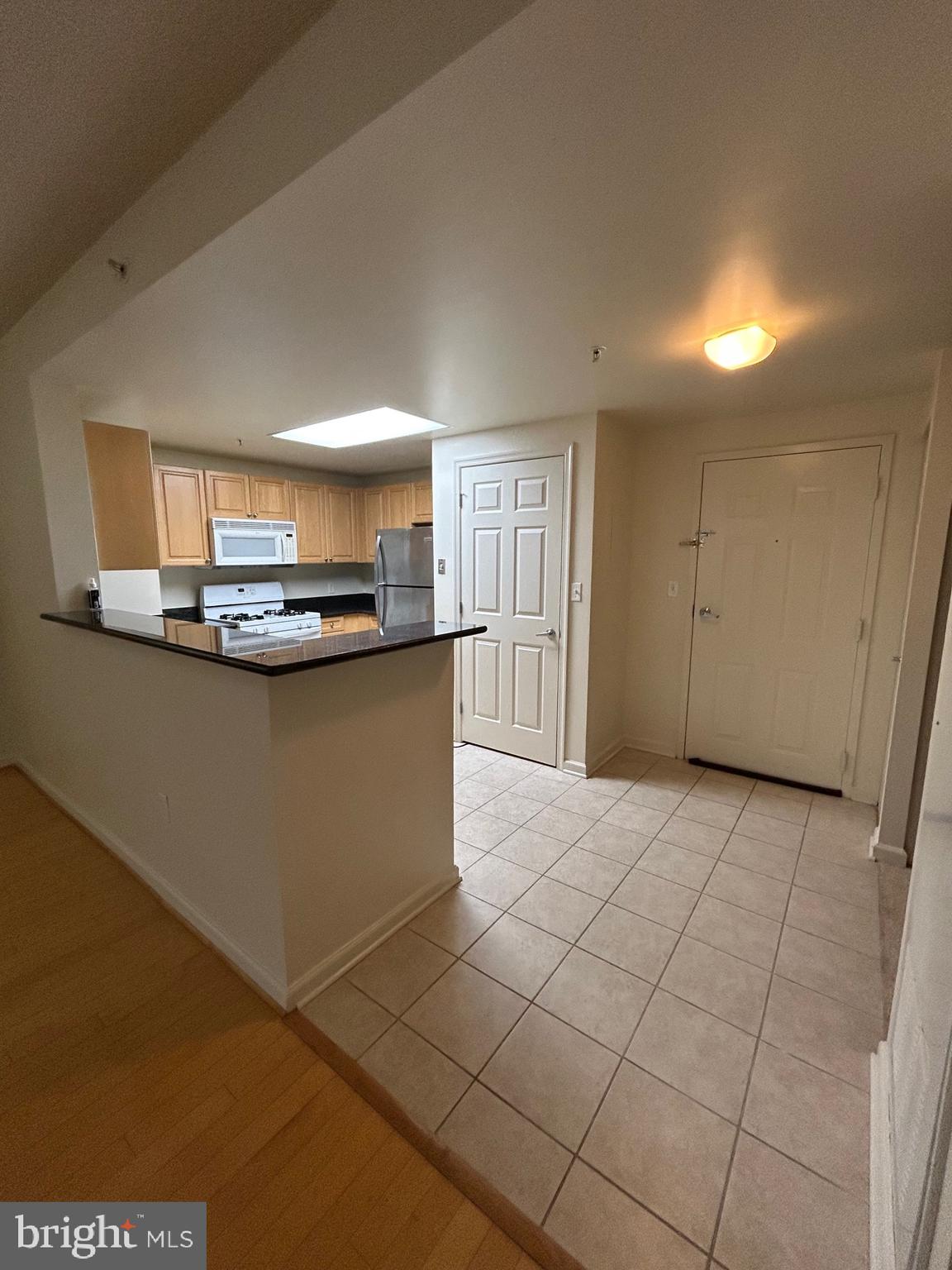 2726 Gallows Road, Unit 1104 Vienna, VA 22180 - Photo 4 of 37 a view of a kitchen with kitchen island white cabinetry a sink and a window