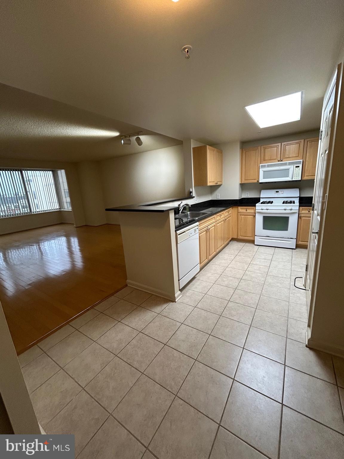 2726 Gallows Road, Unit 1104 Vienna, VA 22180 - Photo 35 of 37 a large kitchen with kitchen island granite countertop a sink and a stove