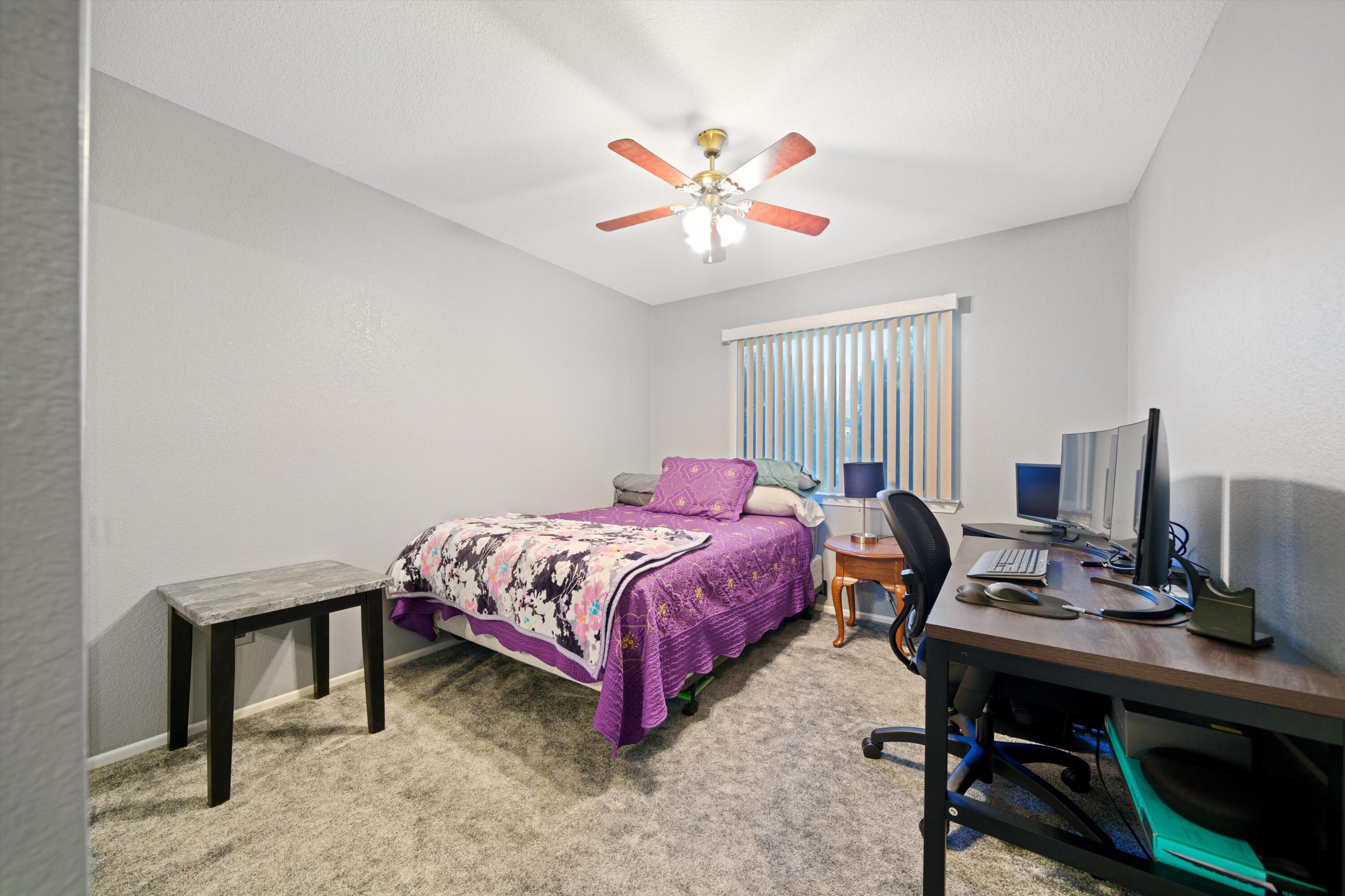 3525 West Roxbury Street Rosamond, CA 93560 - Photo 13 of 26 a bedroom with a bed table and a window