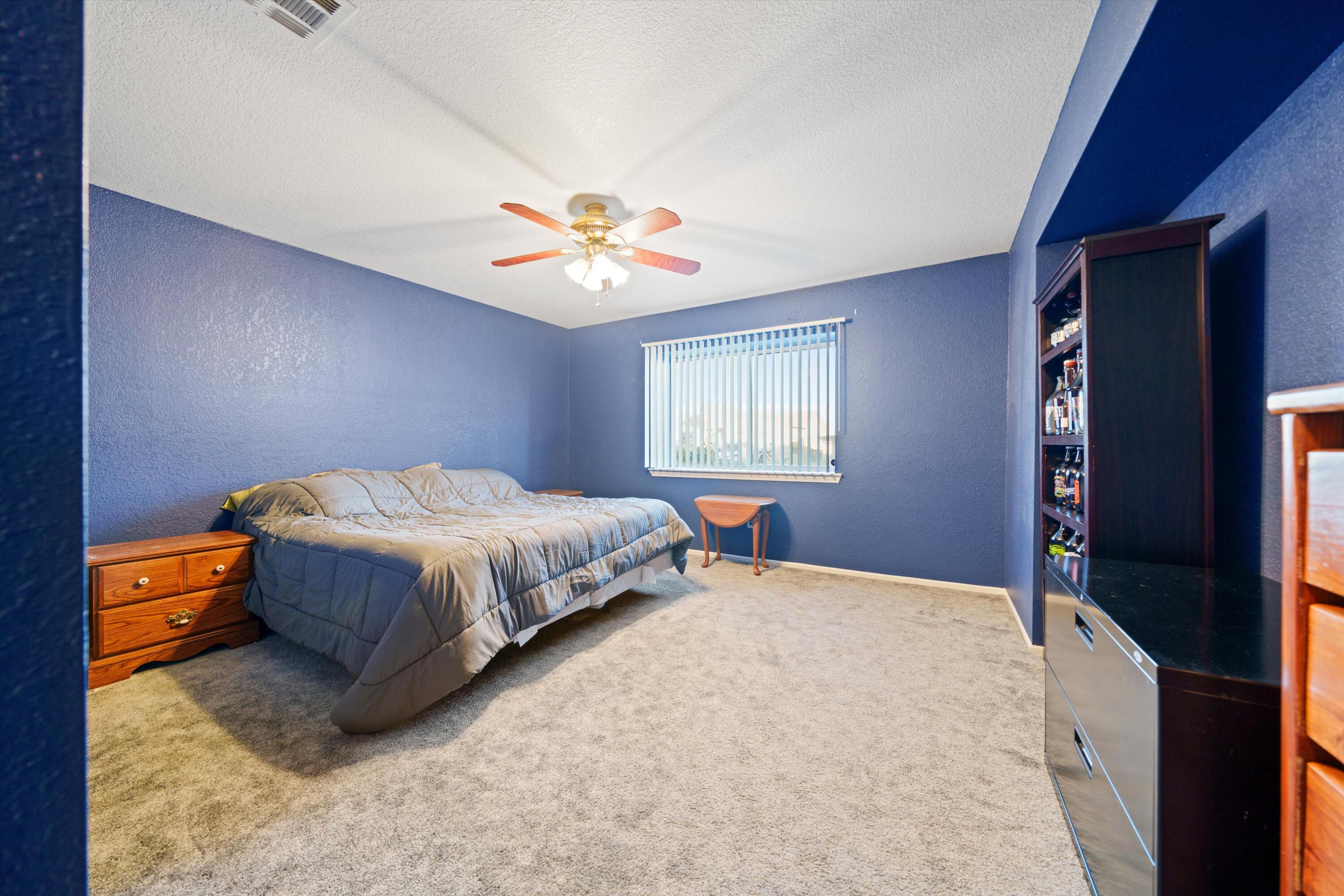 3525 West Roxbury Street Rosamond, CA 93560 - Photo 17 of 26 a spacious bedroom with a bed and a chandelier