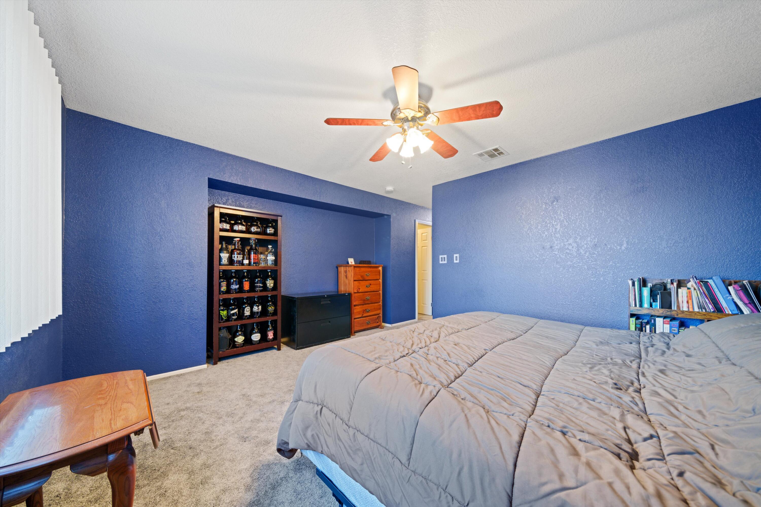 3525 West Roxbury Street Rosamond, CA 93560 - Photo 18 of 26 a bedroom with a bed and a chandelier