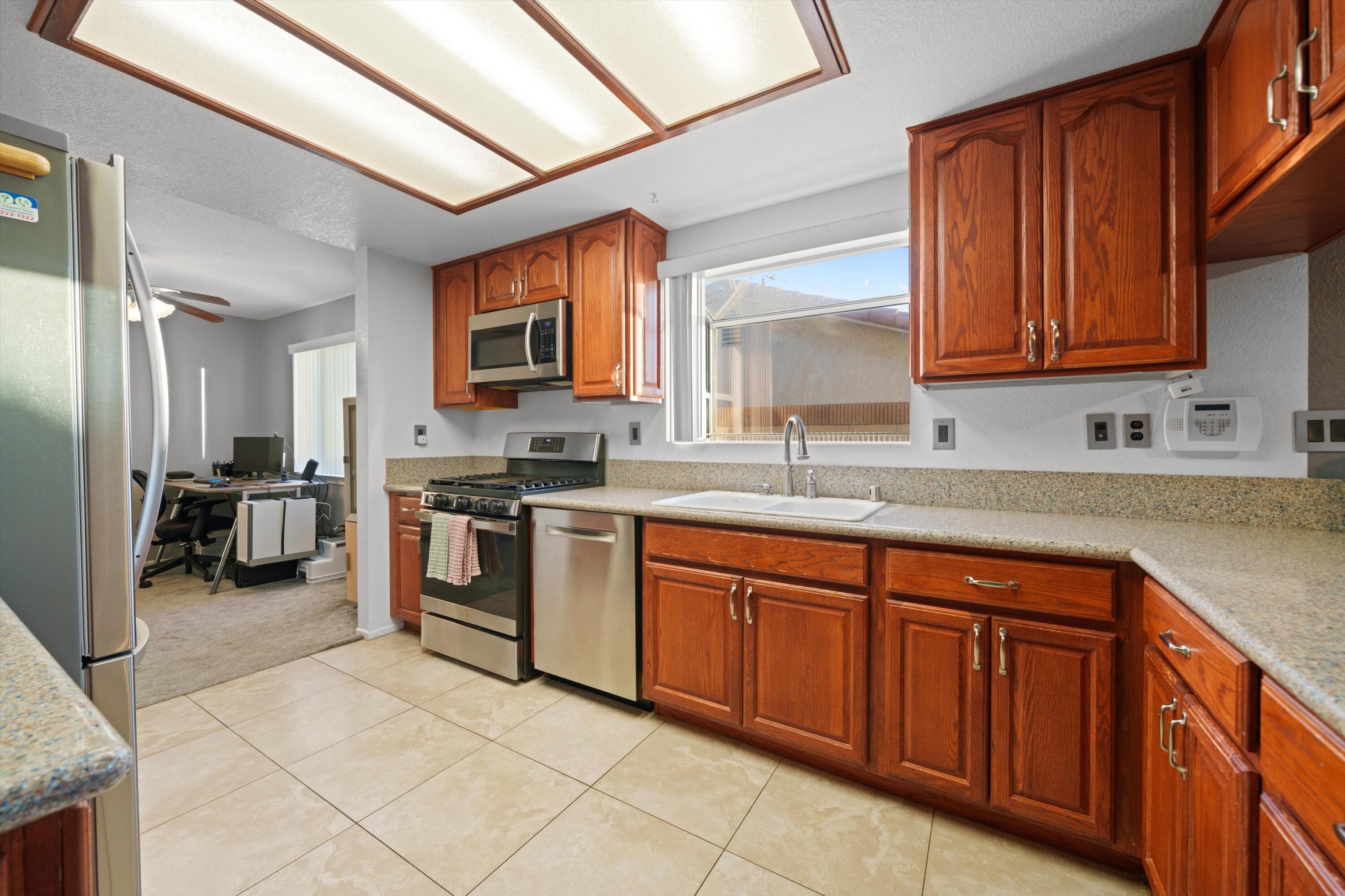 3525 West Roxbury Street Rosamond, CA 93560 - Photo 8 of 26 a kitchen with stainless steel appliances granite countertop a sink and cabinets