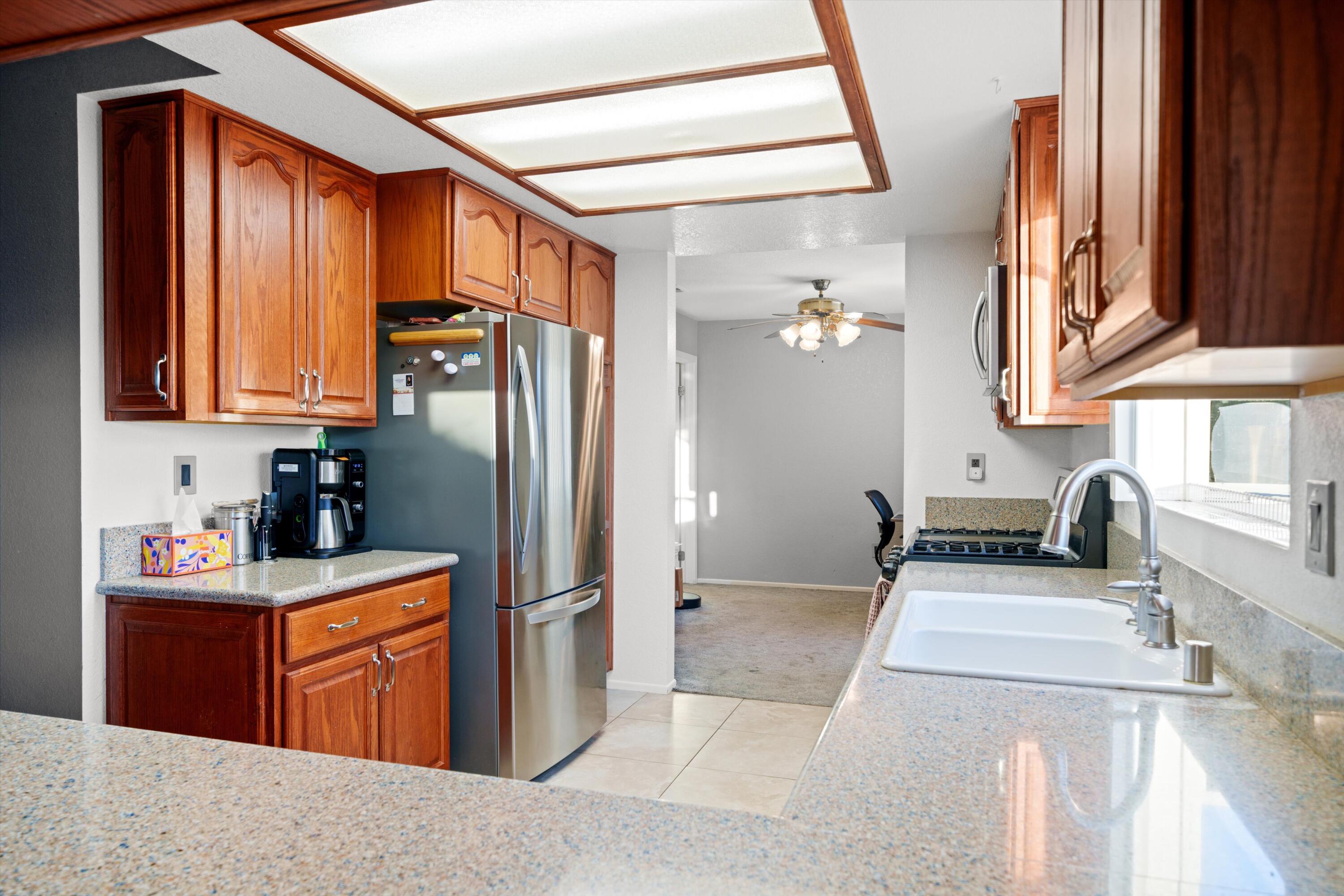 3525 West Roxbury Street Rosamond, CA 93560 - Photo 9 of 26 a kitchen with stainless steel appliances granite countertop a sink stove and refrigerator