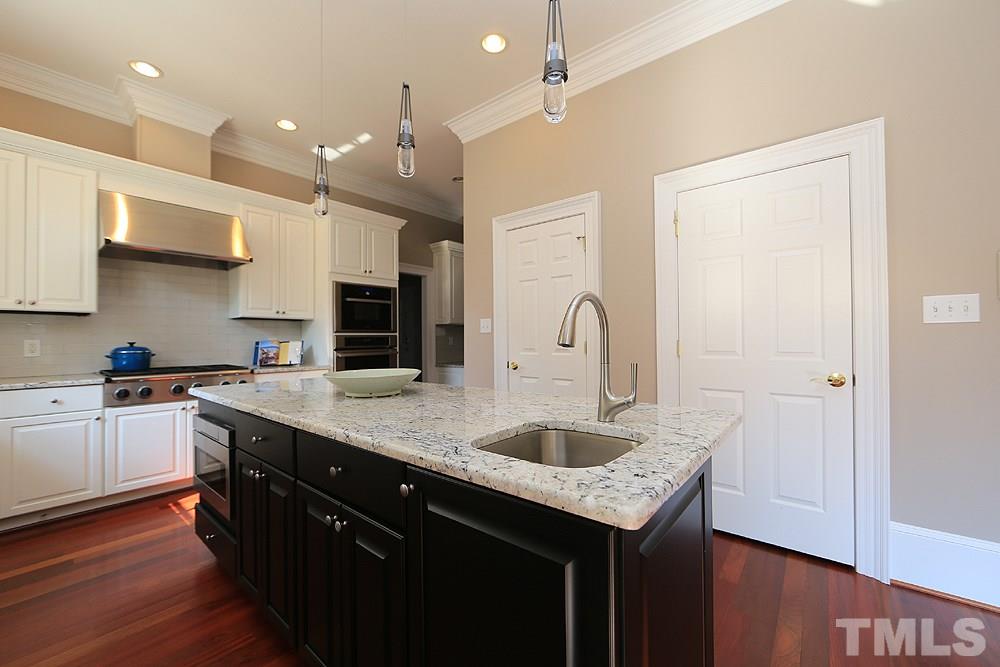 5216 Wynneford Way Raleigh, NC 27614 - Photo 14 of 28 There is room for 4 stools at the island. One of the doors on the wall is a pantry, the other leads to the basement.