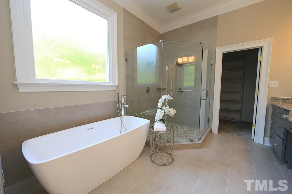 5216 Wynneford Way Raleigh, NC 27614 - Photo 18 of 28 Relax, rejuvenate, refresh in this spa-like master bathroom. There are two large walk-in closets with wood shelving-one at each end of the bathroom.
