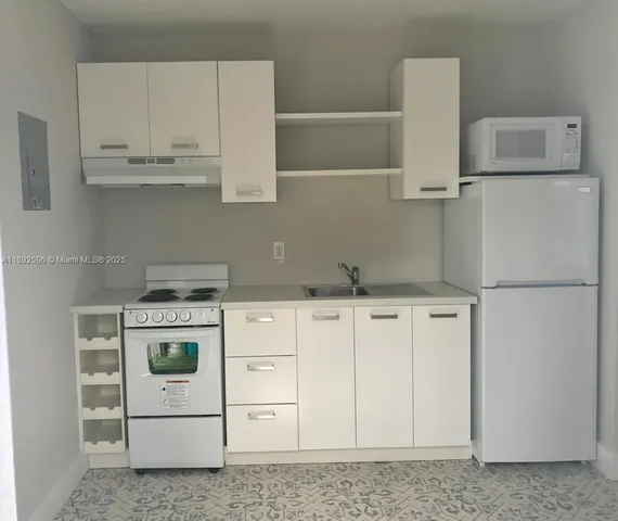 a kitchen with white cabinets and white appliances