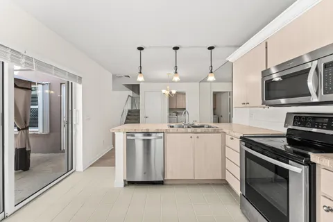 a kitchen with stainless steel appliances a stove a sink and a refrigerator