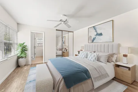 a bedroom with a large bed a chandelier and a couch