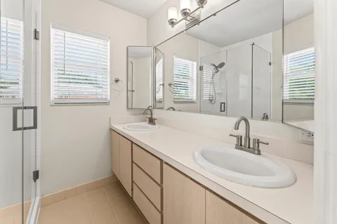 a bathroom with double sink and a mirror