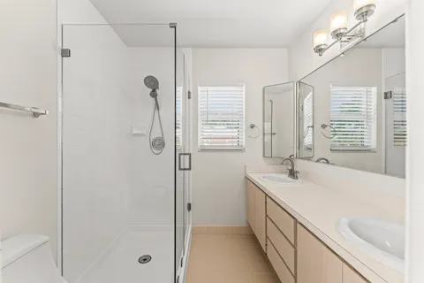 a bathroom with a granite countertop sink a large mirror and shower
