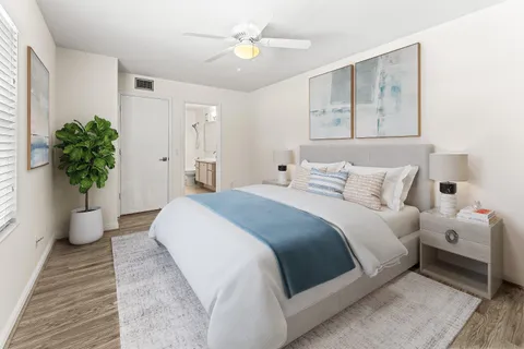 a bedroom with a large bed and a chandelier