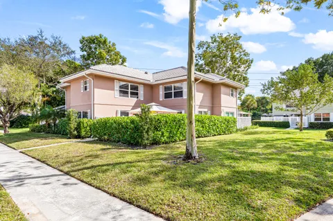 a front view of a house with a yard and trees
