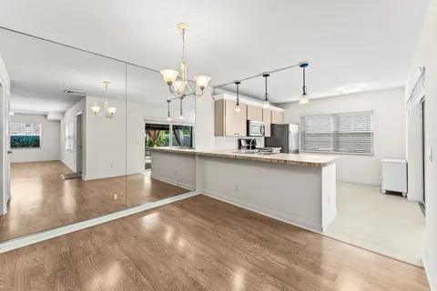 a large kitchen with granite countertop a large counter top space a sink stainless steel appliances and cabinets